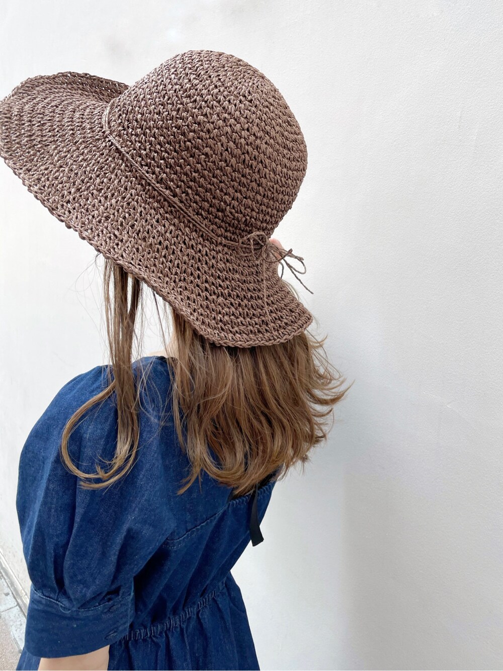 ブルー系のワンピース、ブラウン系のサンダル、ブラウン系のハットを着用したレディースの春コーディネートの7枚目の写真