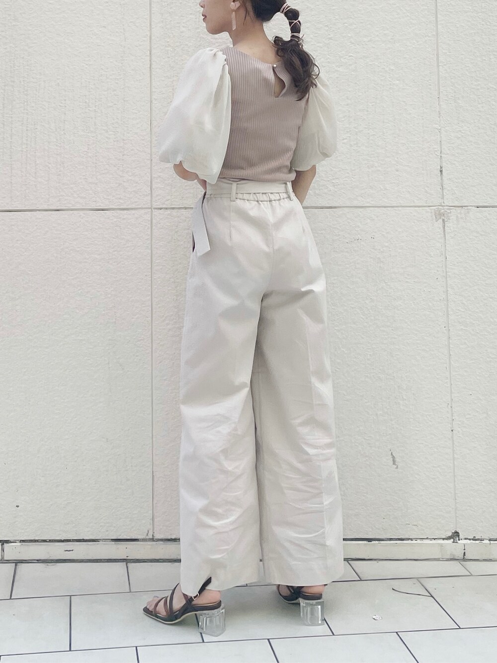 ベージュ系のショルダーバッグ、ホワイト系のその他パンツ、ブラウン系のサンダルを着用したレディースの春コーディネートの2枚目の写真