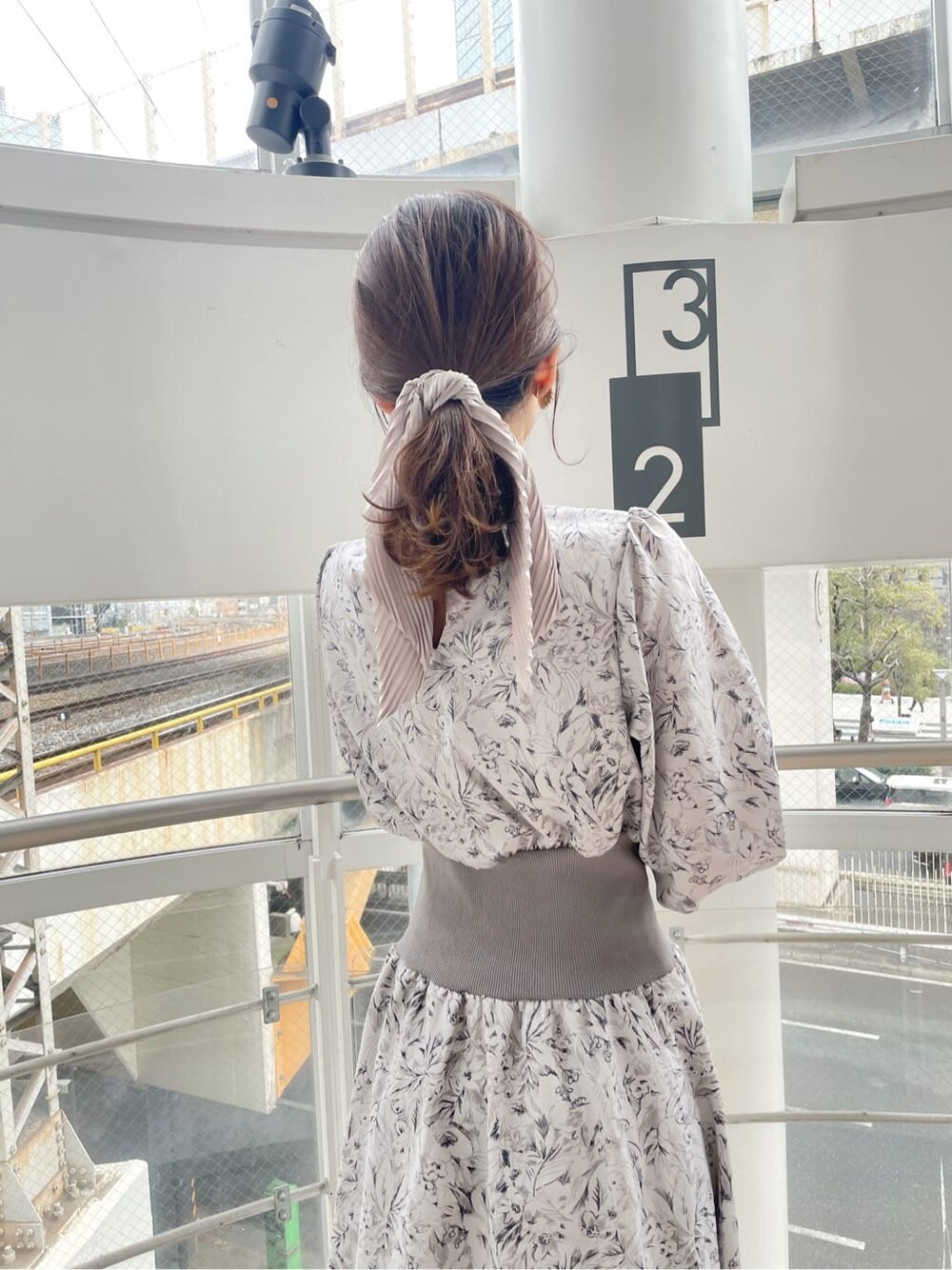 ブルー系のトレンチコート、グレー系のワンピース、ブラック系のローファーを着用したレディースの冬コーディネートの6枚目の写真