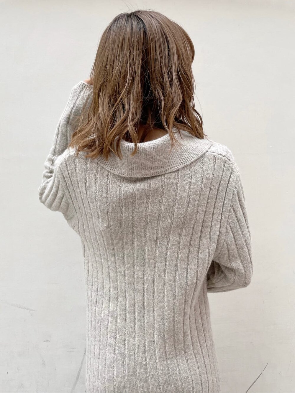 グレー系のワンピース、ホワイト系のハンドバッグ、ベージュ系のブーツを着用したレディースの秋コーディネートの7枚目の写真