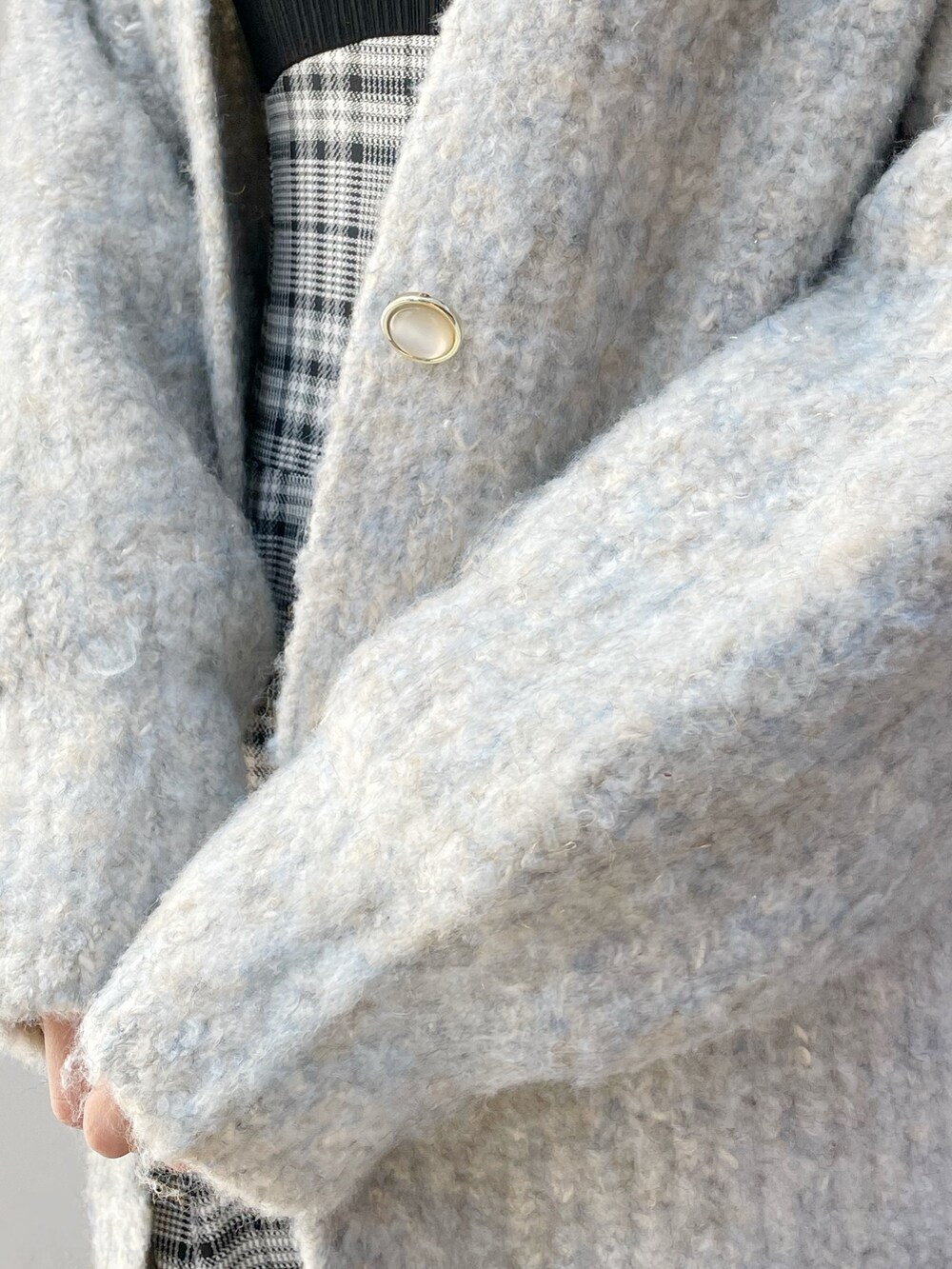 ブルー系のカーディガン/ボレロ、グレー系のワンピース、ブラック系のブーツを着用したレディースの冬コーディネートの9枚目の写真