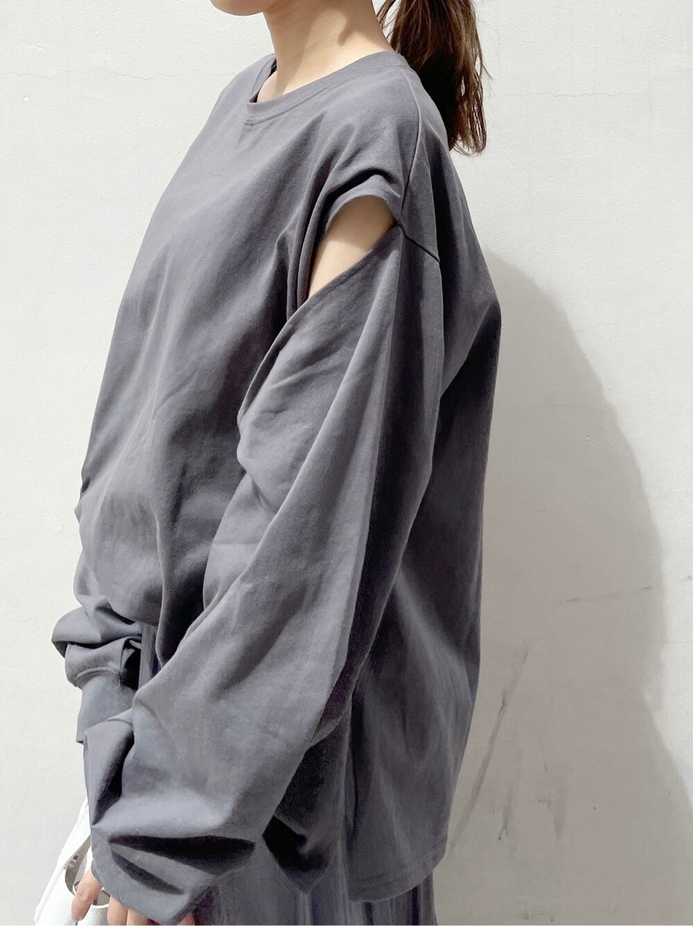 パープル系のスカート、ホワイト系のスニーカー、ホワイト系のハンドバッグを着用したレディースの春コーディネートの6枚目の写真