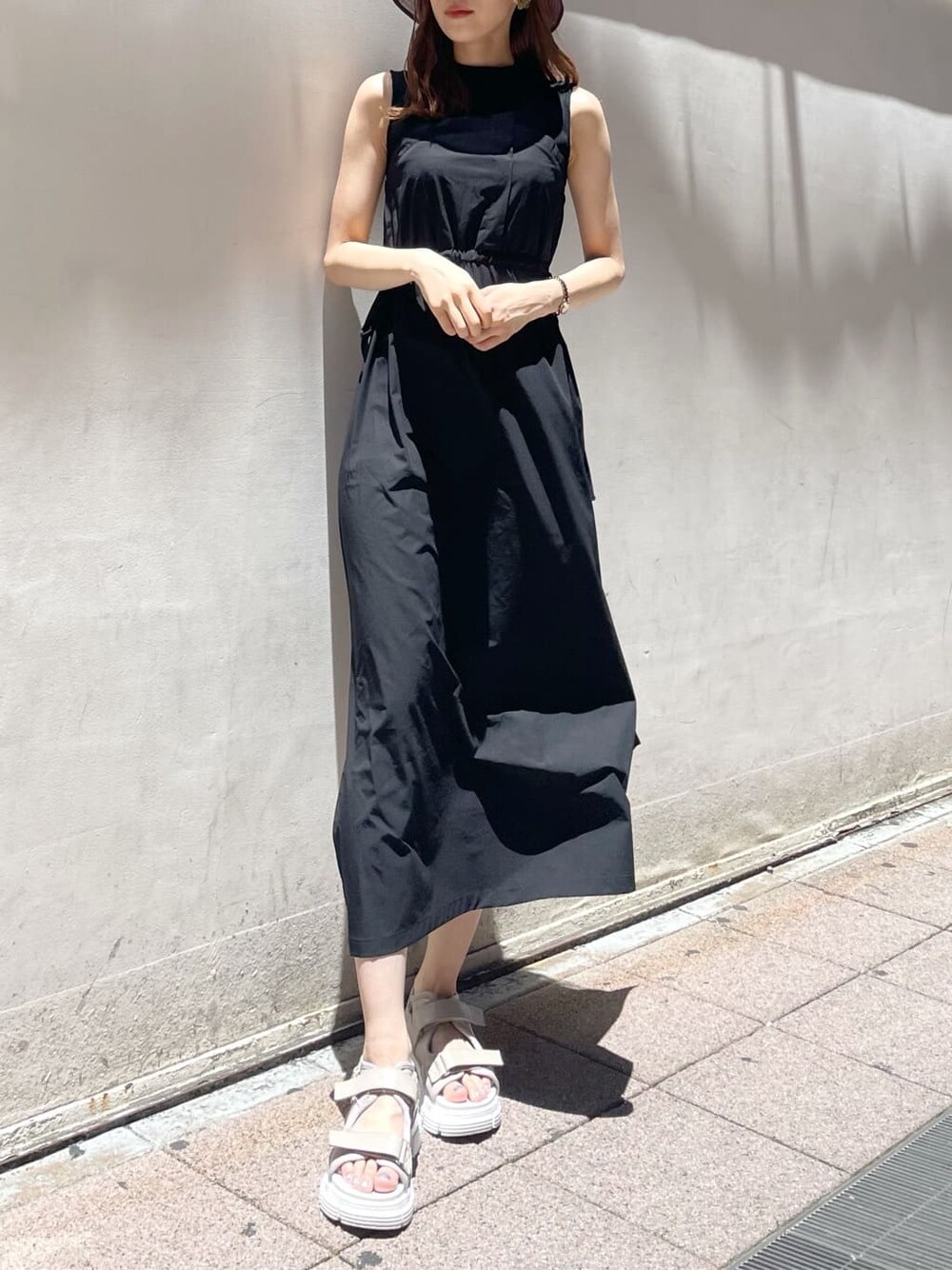 ブラック系のワンピース、ホワイト系のサンダルを着用したレディースの夏コーディネートの3枚目の写真
