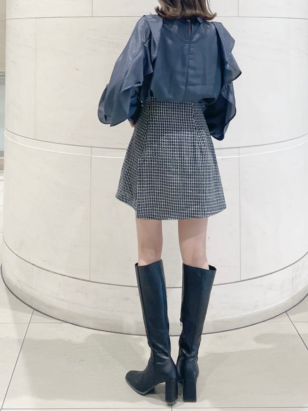 ブルー系のシャツ/ブラウス、ブルー系のスカート、ブラック系のブーツを着用したレディースの秋コーディネートの3枚目の写真