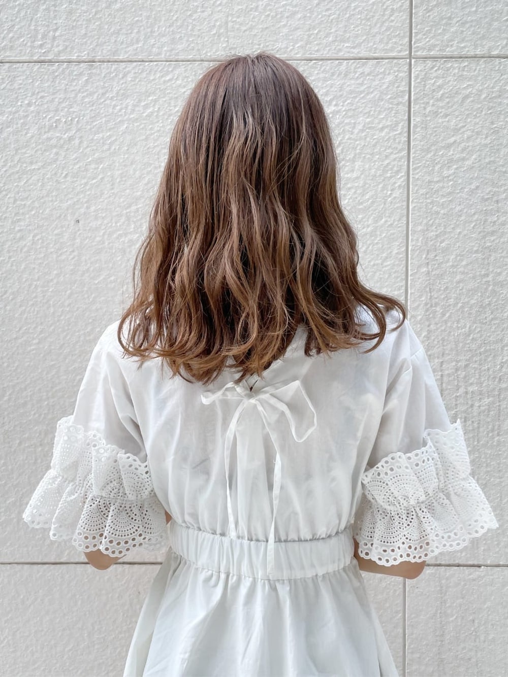 ホワイト系のワンピース、ベージュ系のサンダル、オレンジ系のカーディガン/ボレロを着用したレディースの春コーディネートの8枚目の写真