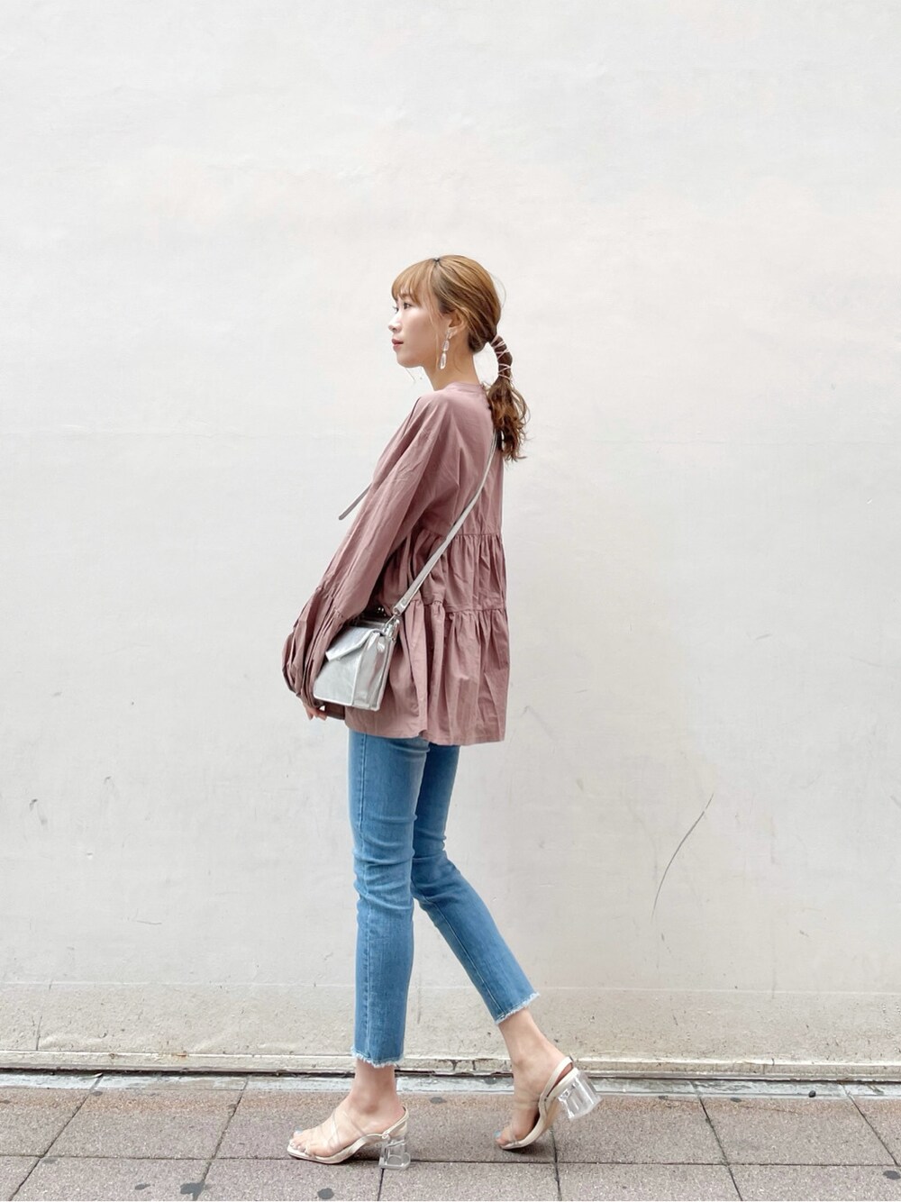 シルバー系のショルダーバッグ、ブルー系のデニムパンツ、ブラウン系のシャツ/ブラウスを着用したレディースの春コーディネートの3枚目の写真