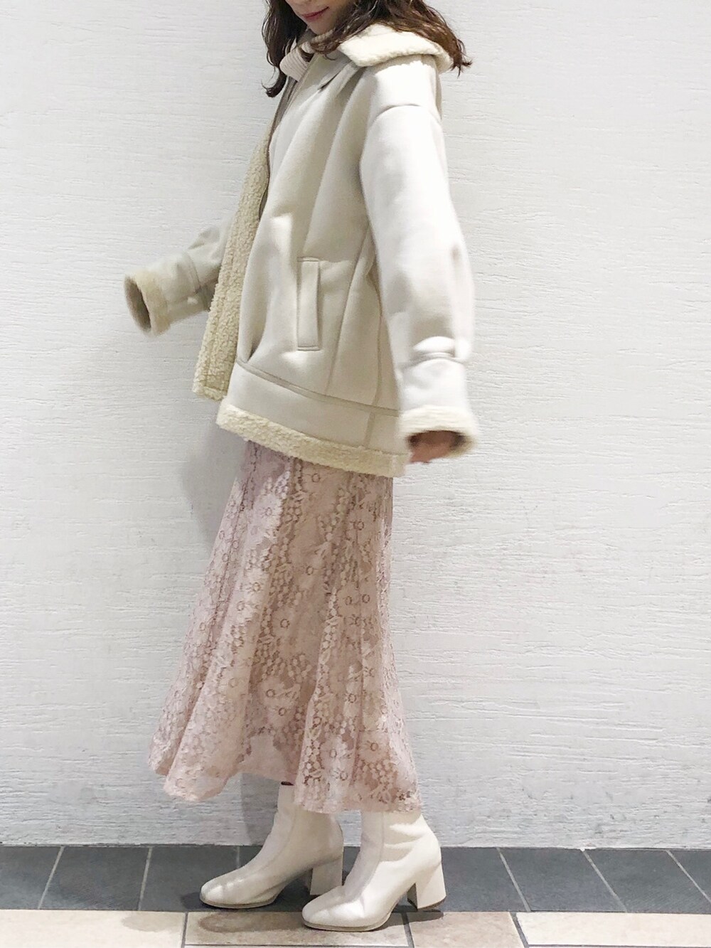 ホワイト系のブーツ、ホワイト系のブルゾン、ホワイト系のニット/セーターを着用したレディースの秋コーディネートの3枚目の写真