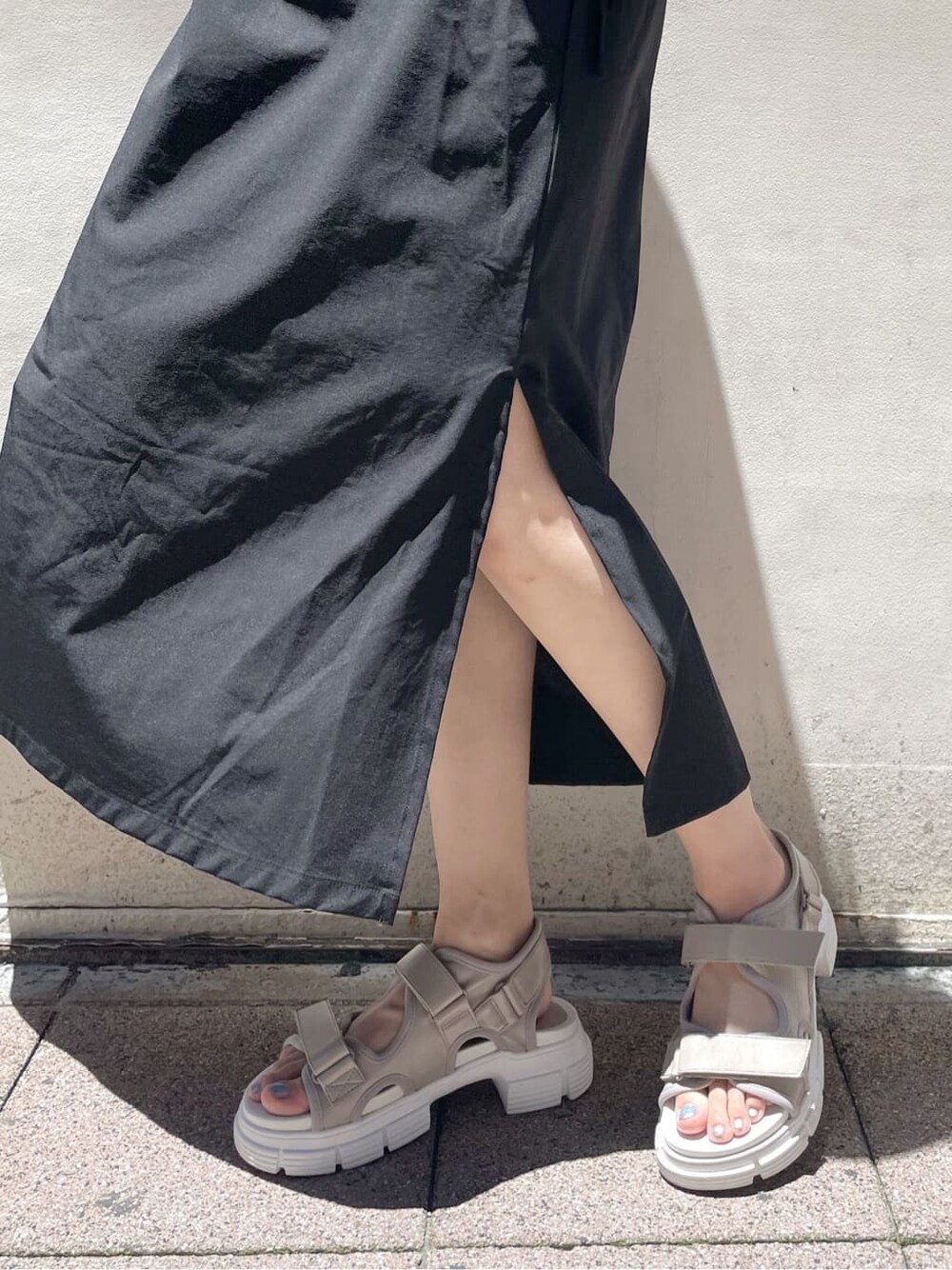 ブラック系のワンピース、ホワイト系のサンダルを着用したレディースの夏コーディネートの8枚目の写真