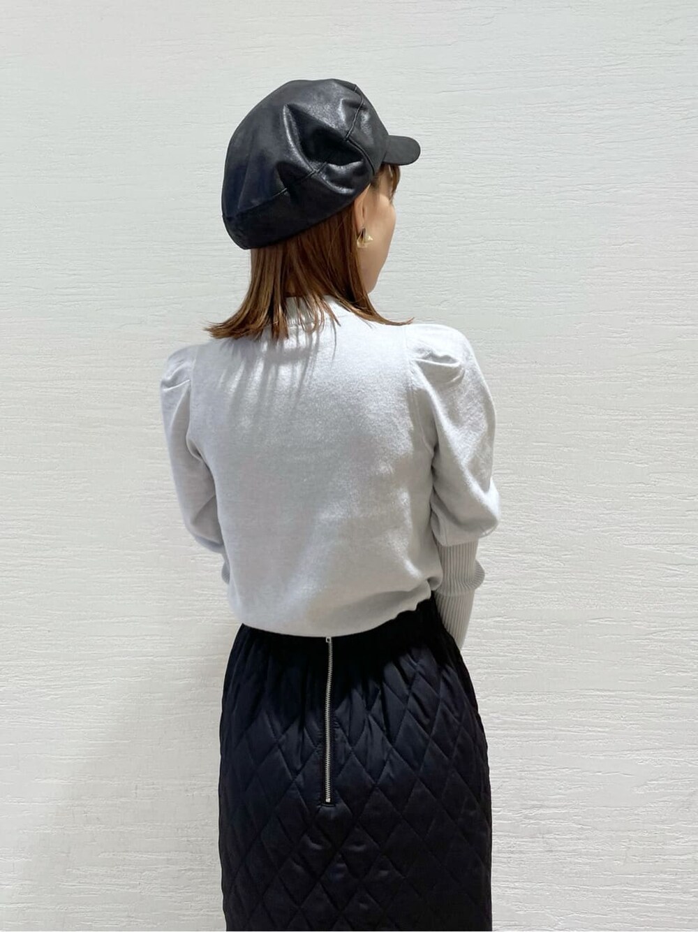 ブラック系のスカート、ブラック系のショルダーバッグ、グレー系のニット/セーターを着用したレディースの秋コーディネートの6枚目の写真