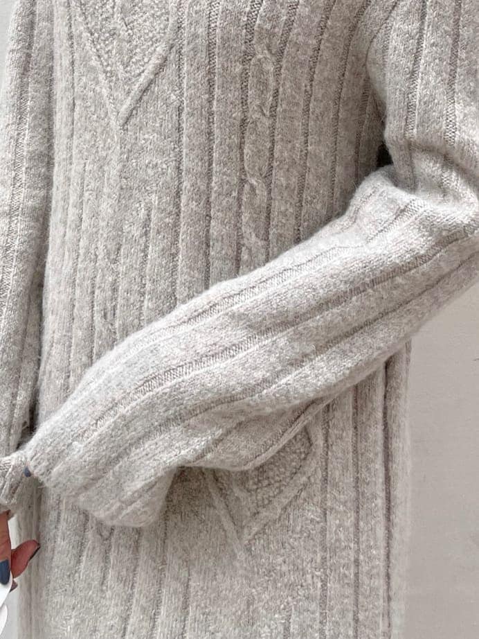 グレー系のワンピース、ホワイト系のハンドバッグ、ベージュ系のブーツを着用したレディースの秋コーディネートの8枚目の写真