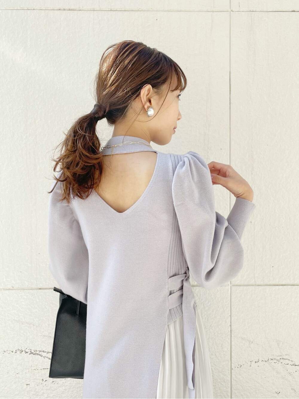 ブラック系のブーツ、ブラック系のハンドバッグ、グレー系のワンピースを着用したレディースの冬コーディネートの6枚目の写真