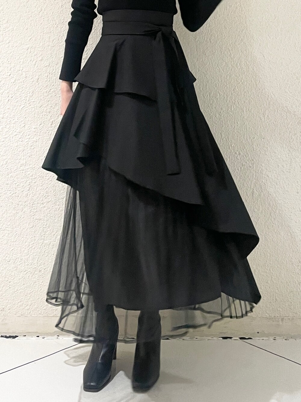 ブラック系のニット/セーター、ブラック系のブーツ、ブラック系のスカートを着用したレディースの冬コーディネートの8枚目の写真