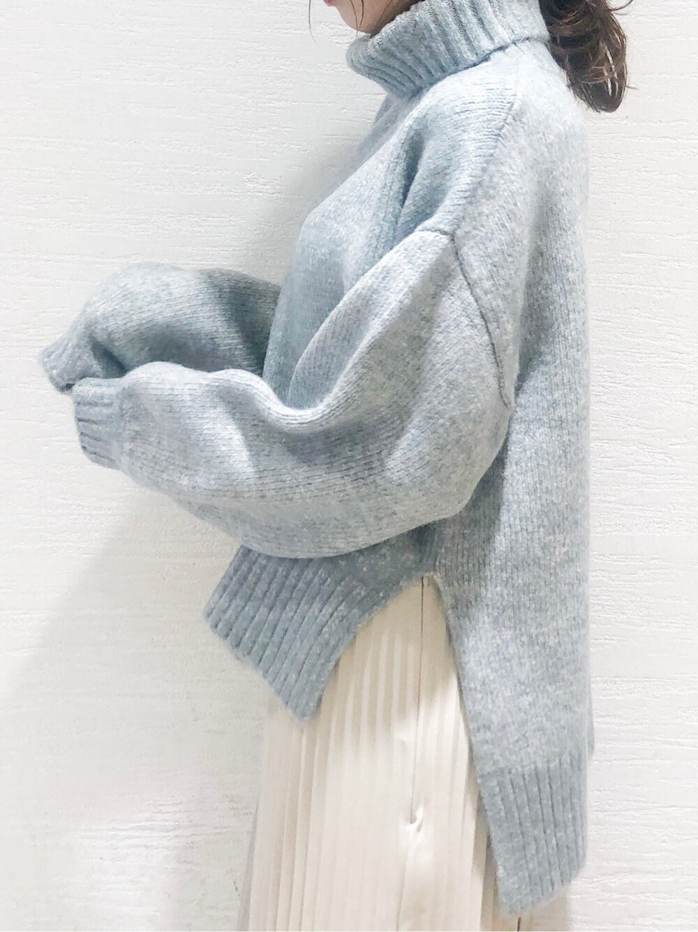 ベージュ系のスカート、ホワイト系のブーツ、グレー系のニット/セーターを着用したレディースの秋コーディネートの3枚目の写真