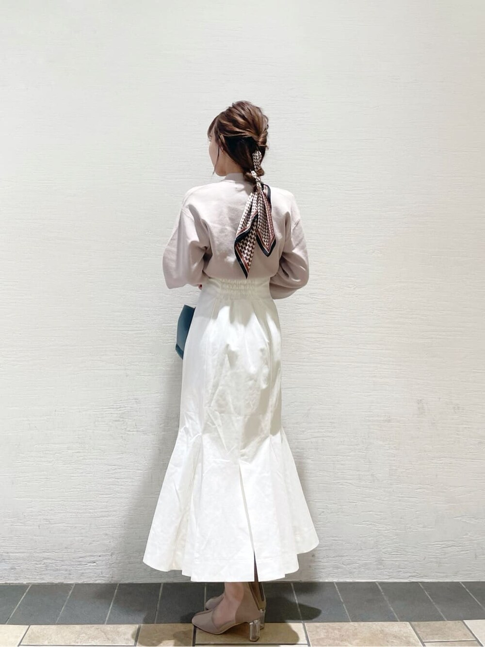 ベージュ系のニット/セーター、ブルー系のハンドバッグ、ベージュ系のブーツを着用したレディースの冬コーディネートの3枚目の写真