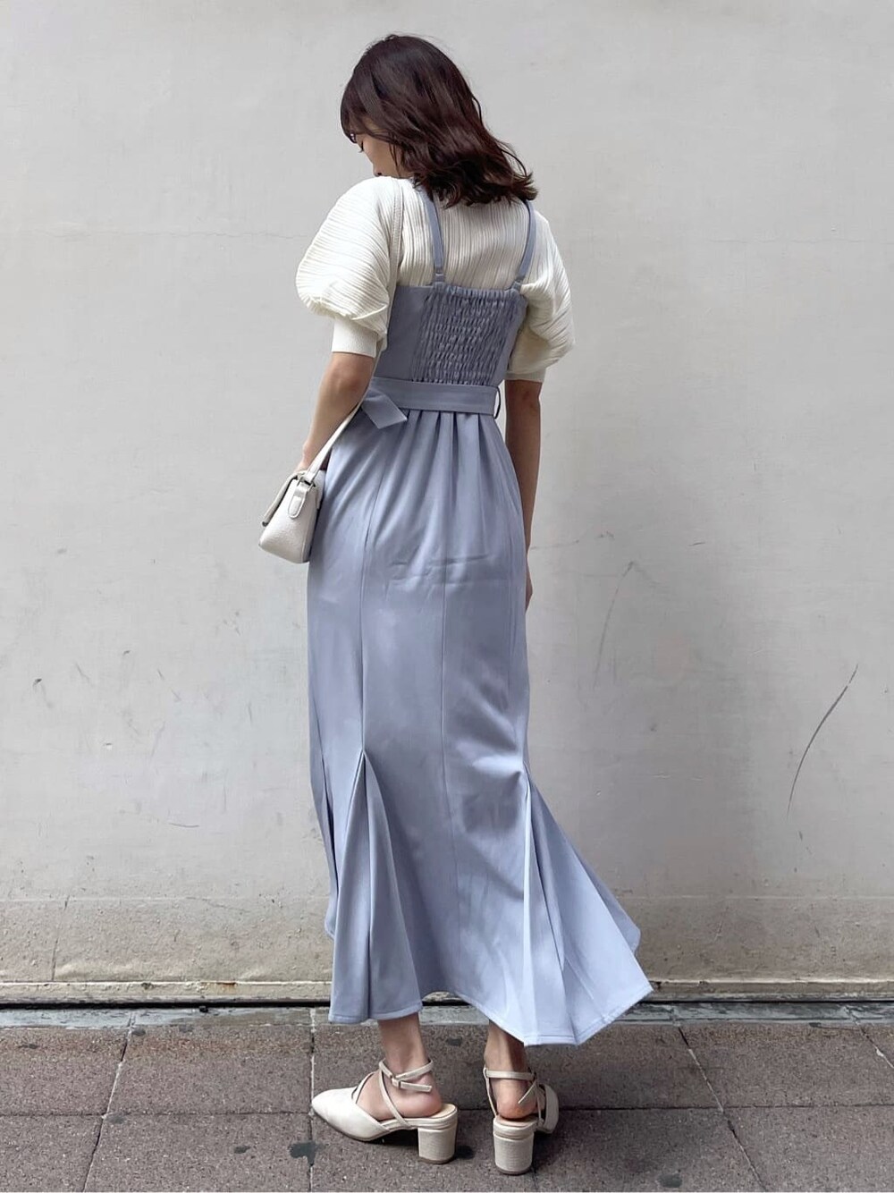 ブルー系のワンピース、ホワイト系のニット/セーター、ホワイト系のパンプスを着用したレディースの春コーディネートの3枚目の写真