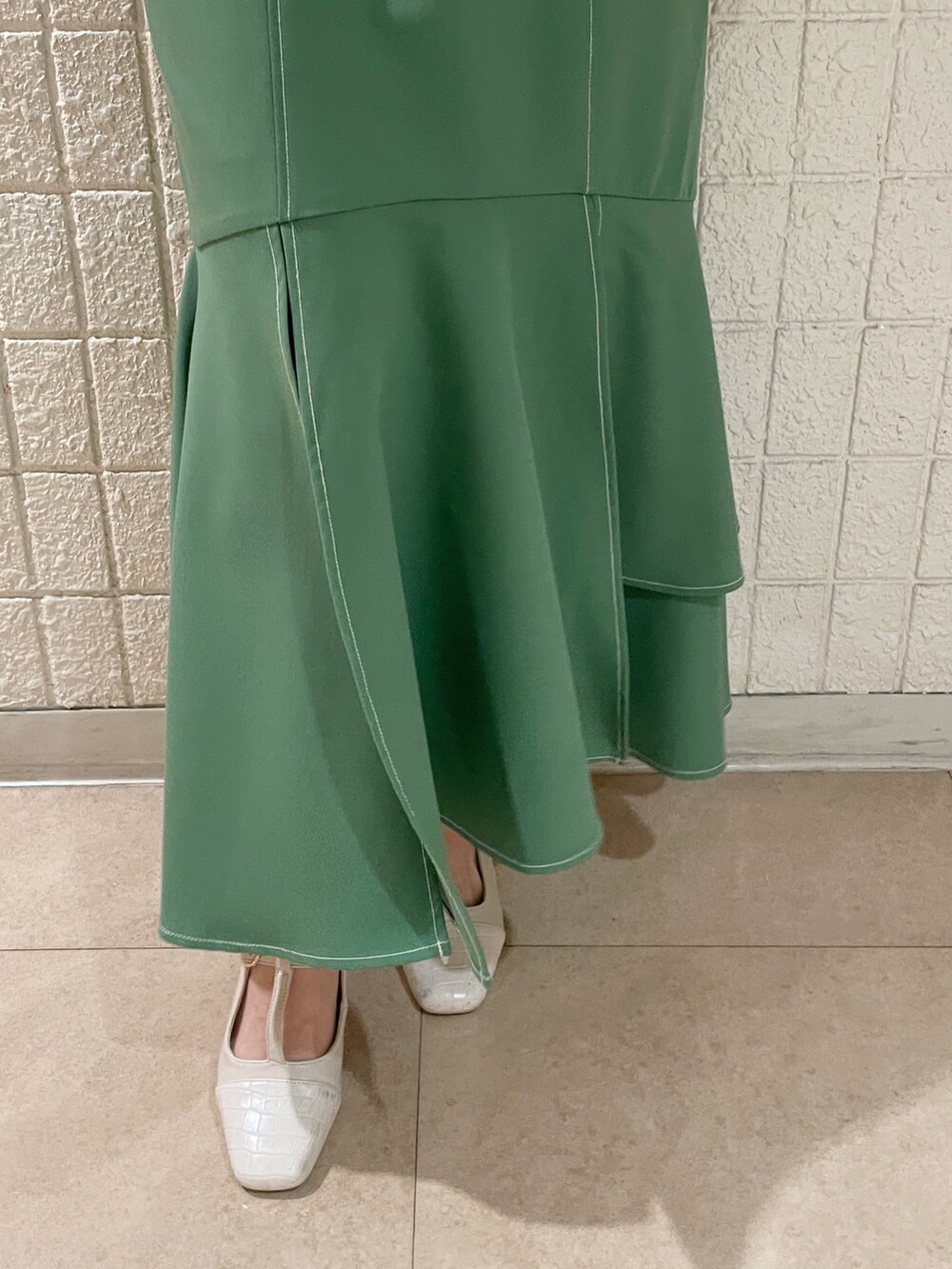 ホワイト系のシャツ/ブラウス、グリーン系のスカート、ホワイト系のパンプスを着用したレディースの春コーディネートの8枚目の写真