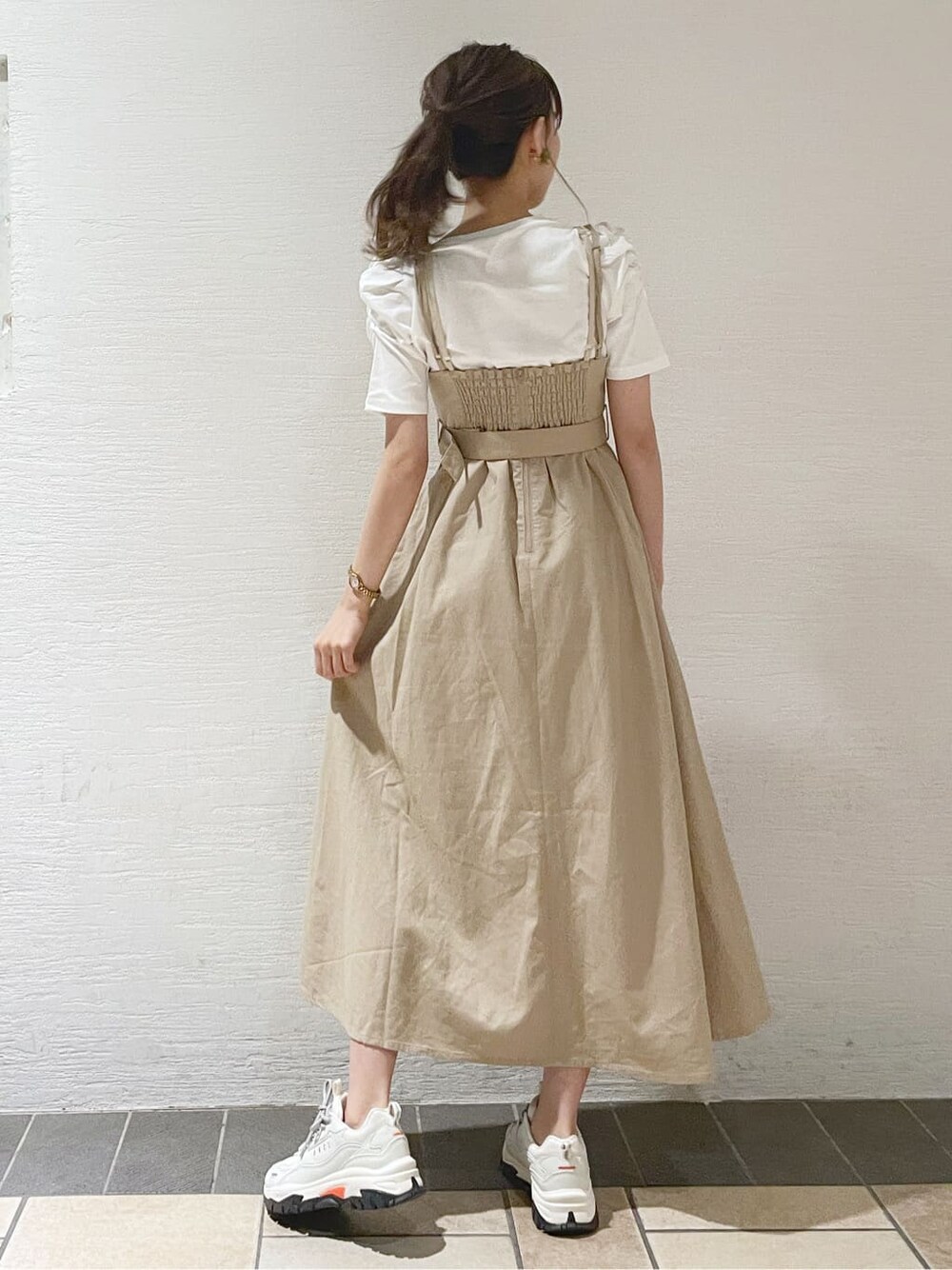 ホワイト系のスニーカー、ベージュ系のワンピース、ホワイト系のTシャツ/カットソーを着用したレディースの春コーディネートの3枚目の写真