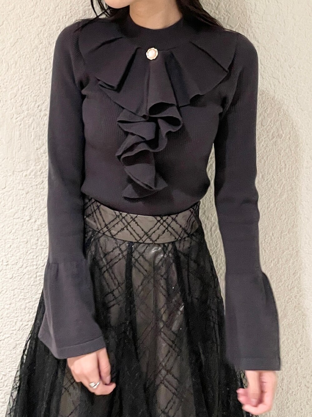 ブラック系のブーツ、ブラック系のニット/セーター、ブラック系のスカートを着用したレディースの冬コーディネートの6枚目の写真