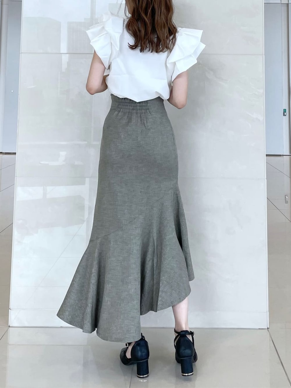 ホワイト系のシャツ/ブラウス、グリーン系のスカート、ブラック系のパンプスを着用したレディースの秋コーディネートの3枚目の写真