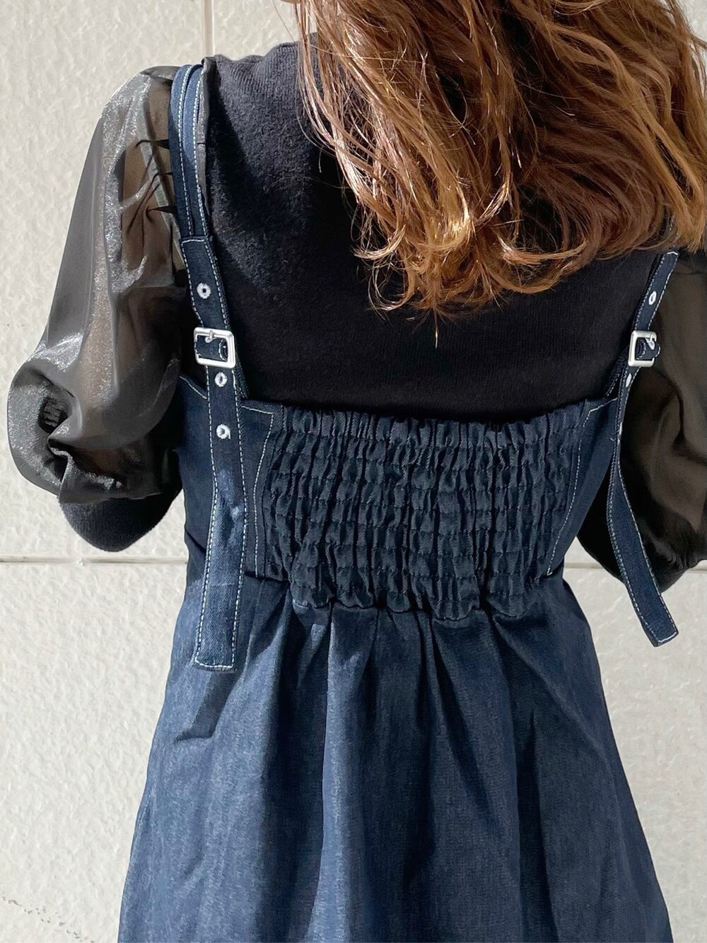 ホワイト系のブーツ、ブラック系のニット/セーター、ブルー系のワンピースを着用したレディースの冬コーディネートの3枚目の写真