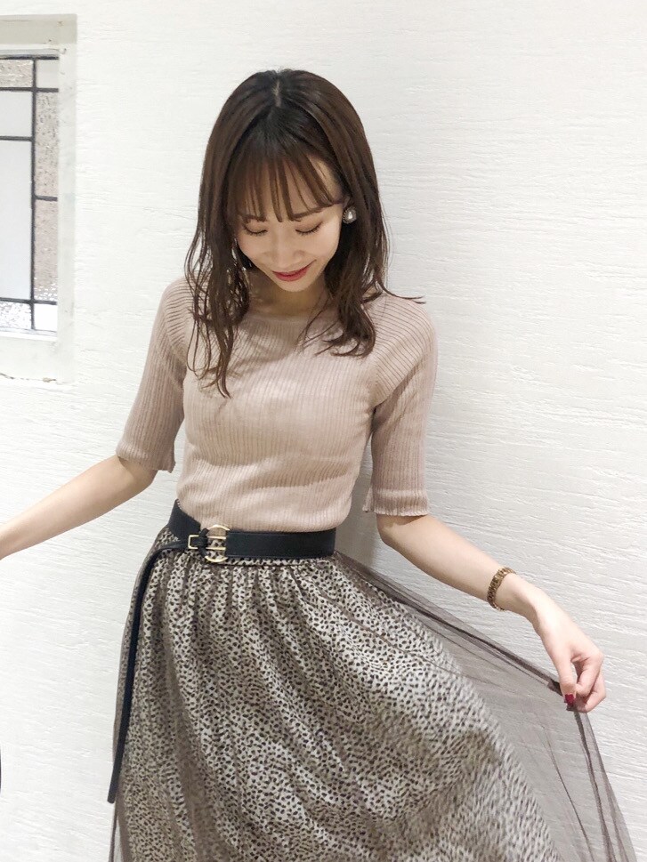 ピンク系のニット/セーター、ブラック系のパンプス、ブラウン系のスカートを着用したレディースの夏コーディネートの4枚目の写真