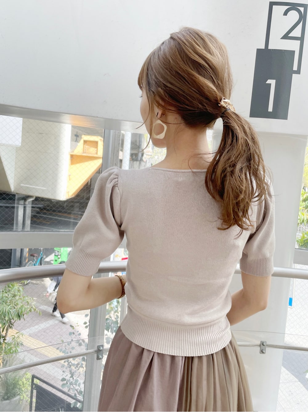 ブラウン系のスカート、ベージュ系のサンダル、ホワイト系のハンドバッグを着用したレディースの春コーディネートの7枚目の写真