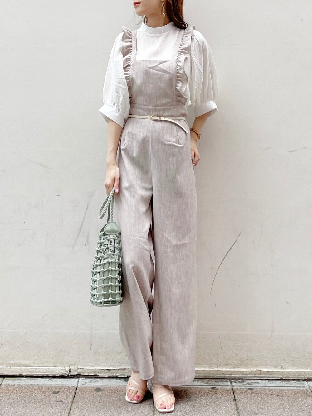 ブラウン系のサロペット/オーバーオール、ホワイト系のシャツ/ブラウス、グリーン系のショルダーバッグを着用したレディースの夏コーディネートの2枚目の写真