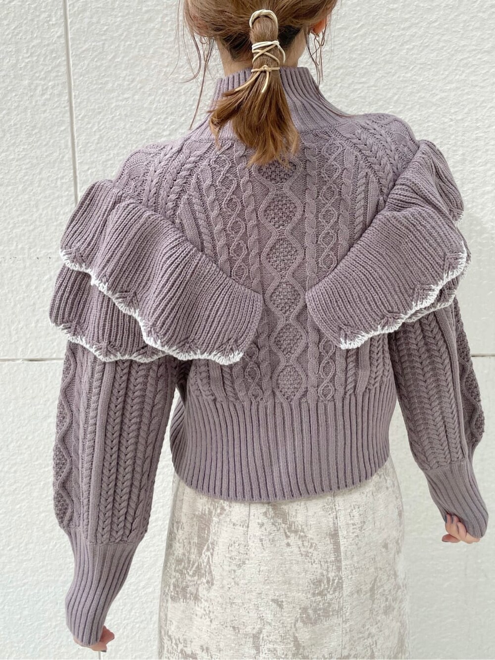 ベージュ系のスカート、ブラック系のブーツ、パープル系のニット/セーターを着用したレディースの秋コーディネートの6枚目の写真