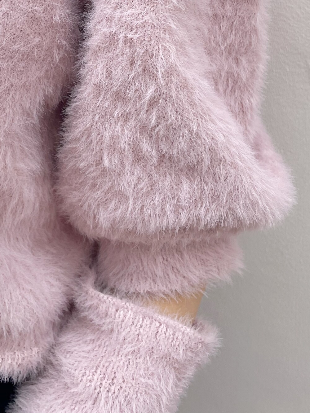 ピンク系のニット/セーター、ブラック系のスカート、ブラック系のブーツを着用したレディースの冬コーディネートの10枚目の写真