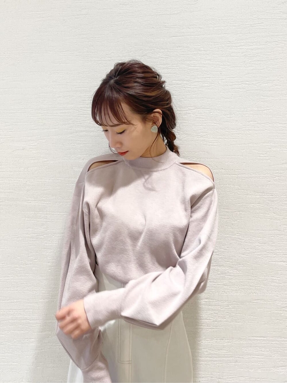 ベージュ系のニット/セーター、ブルー系のハンドバッグ、ベージュ系のブーツを着用したレディースの冬コーディネートの4枚目の写真