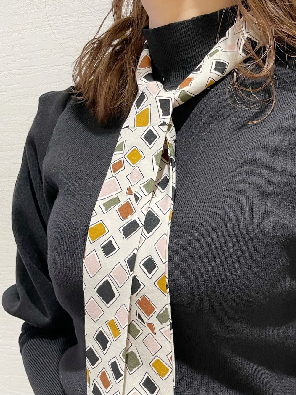 パープル系のスカート、ブラック系のニット/セーター、ブラック系のブーツを着用したレディースの冬コーディネートの8枚目の写真
