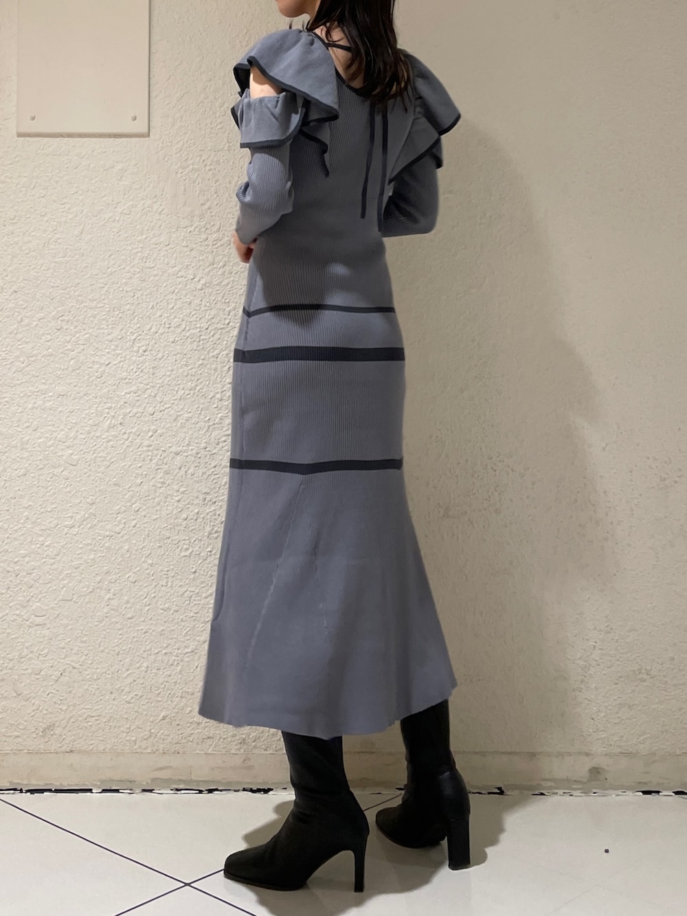 グレー系のワンピース、ブラック系のブーツを着用したレディースの冬コーディネートの2枚目の写真