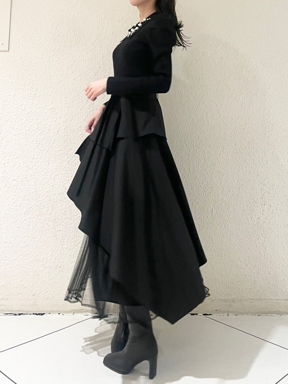 ブラック系のニット/セーター、ブラック系のブーツ、ブラック系のスカートを着用したレディースの冬コーディネートの2枚目の写真