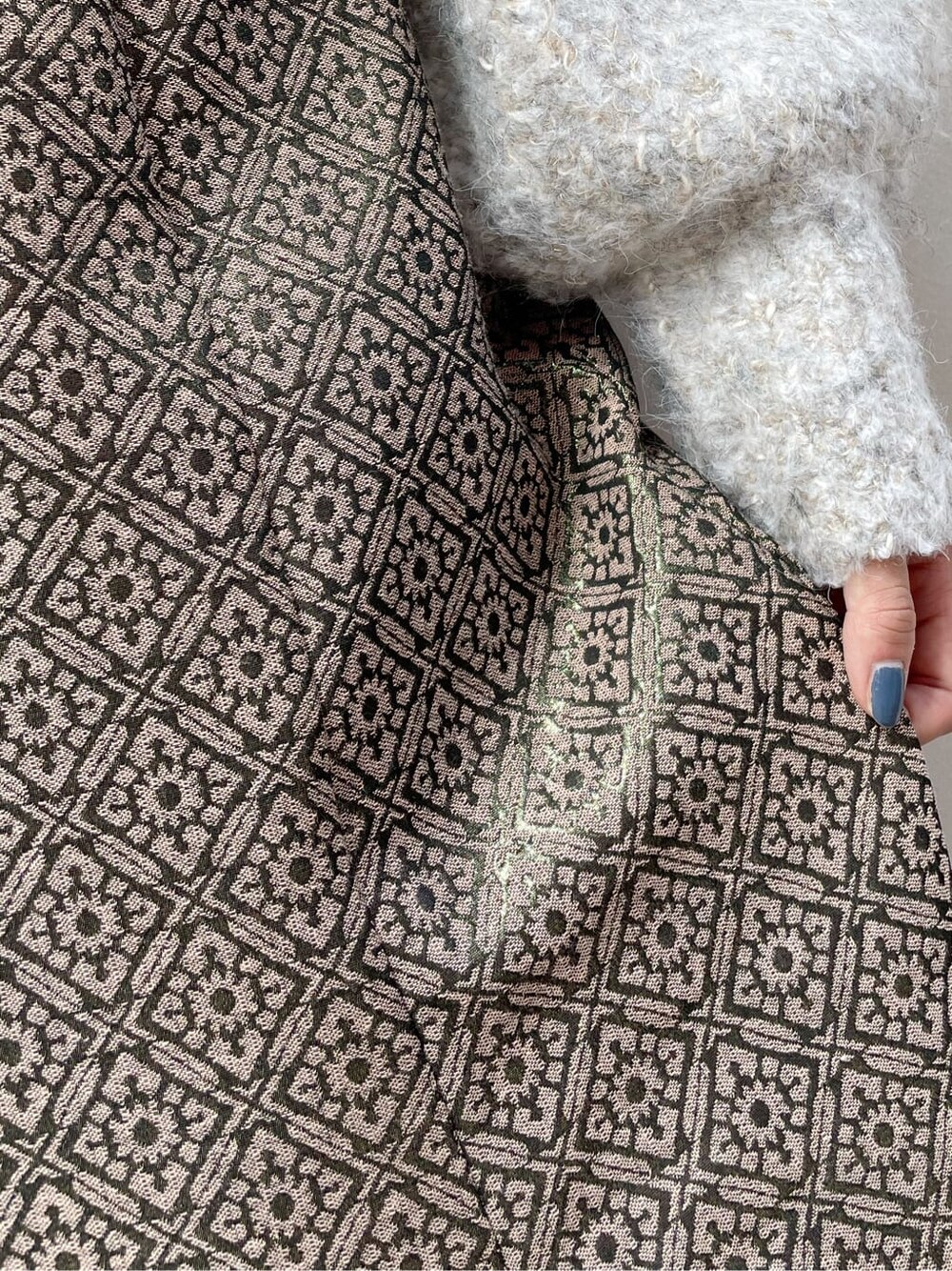 ブラック系のブーツ、ベージュ系のニット/セーター、ゴールド系のスカートを着用したレディースの秋コーディネートの10枚目の写真