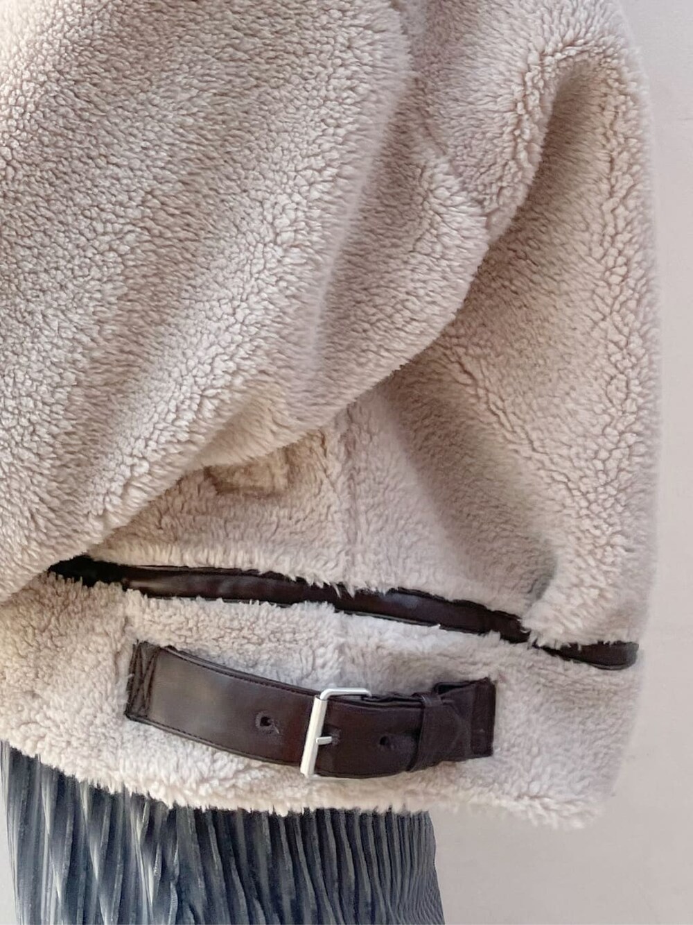 ベージュ系のブルゾン、ブラック系のブーツ、ブルー系のスカートを着用したレディースの秋コーディネートの5枚目の写真