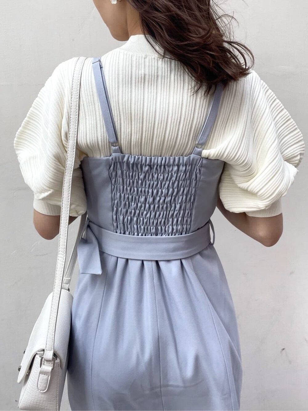 ブルー系のワンピース、ホワイト系のニット/セーター、ホワイト系のパンプスを着用したレディースの春コーディネートの6枚目の写真