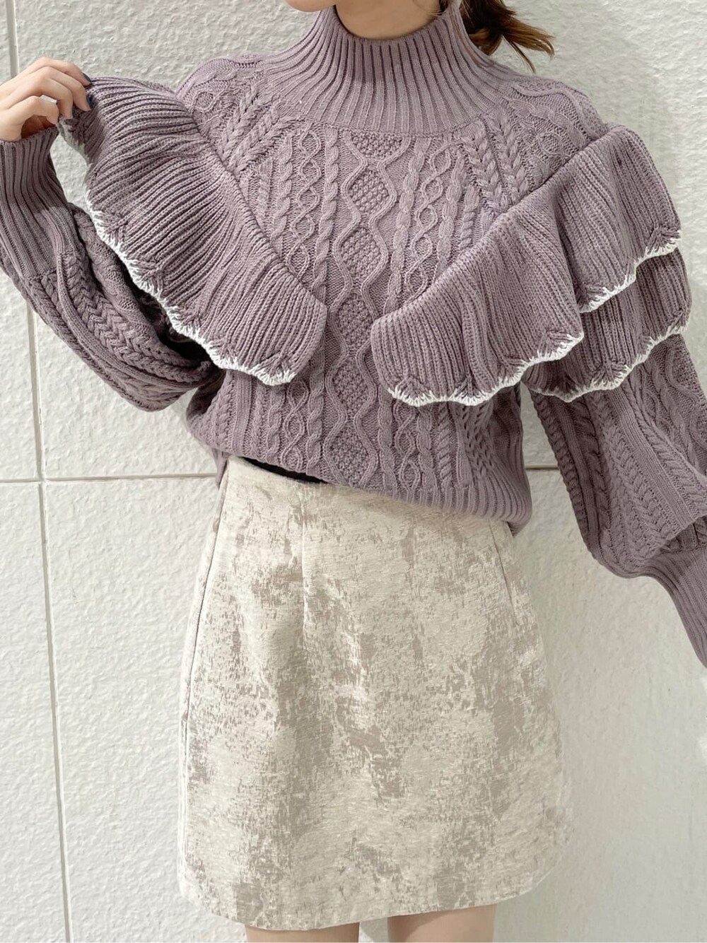 ベージュ系のスカート、ブラック系のブーツ、パープル系のニット/セーターを着用したレディースの秋コーディネートの4枚目の写真