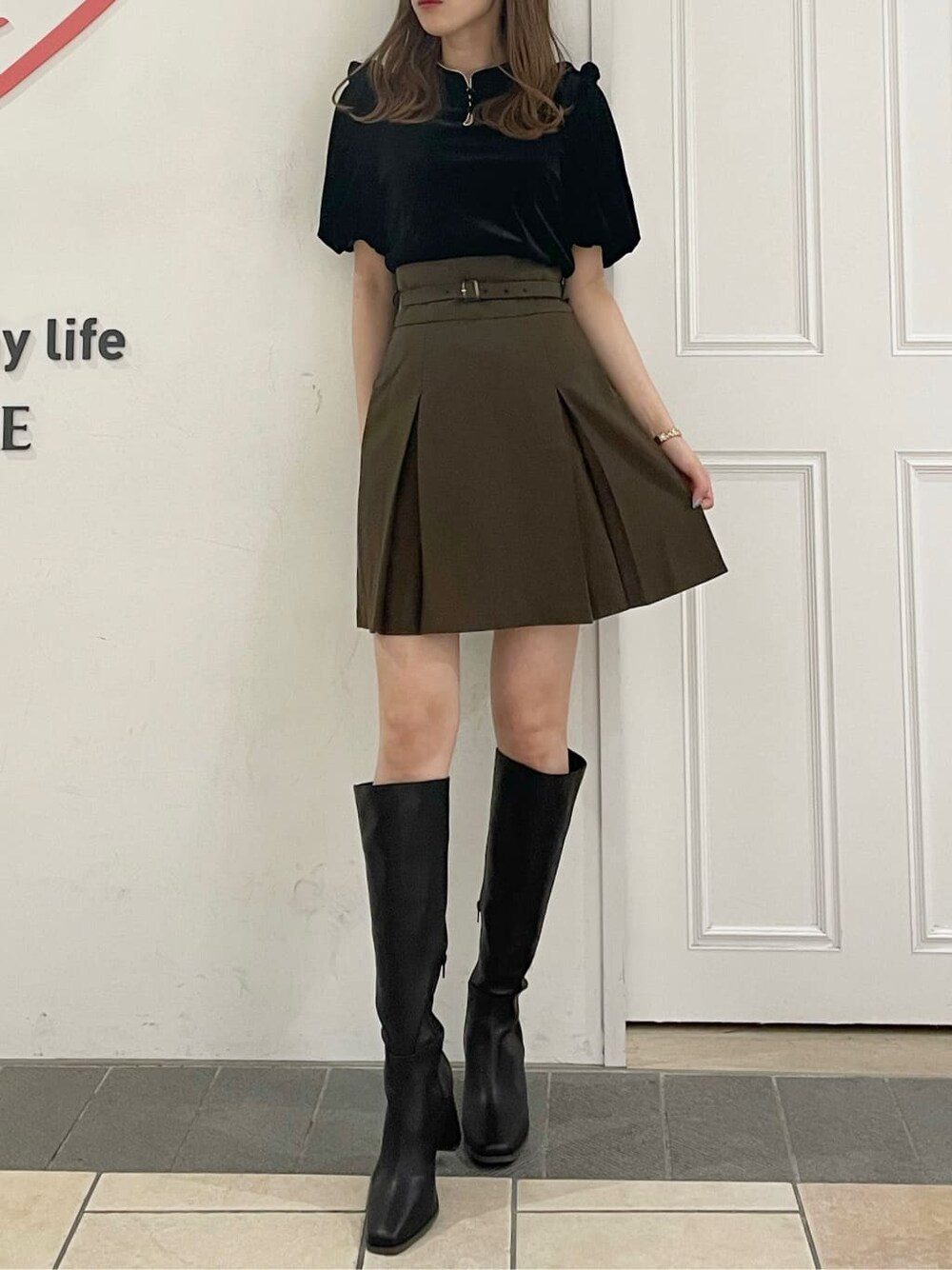 ブラウン系のスカート、ブラック系のブーツ、ブラック系のTシャツ/カットソーを着用したレディースの夏コーディネートの4枚目の写真