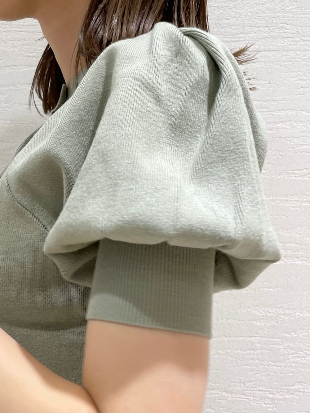 グレー系のその他パンツ、ホワイト系のハンドバッグ、グリーン系のニット/セーターを着用したレディースの夏コーディネートの7枚目の写真