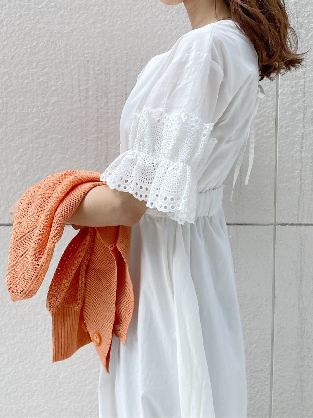 ホワイト系のワンピース、ベージュ系のサンダル、オレンジ系のカーディガン/ボレロを着用したレディースの春コーディネートの7枚目の写真