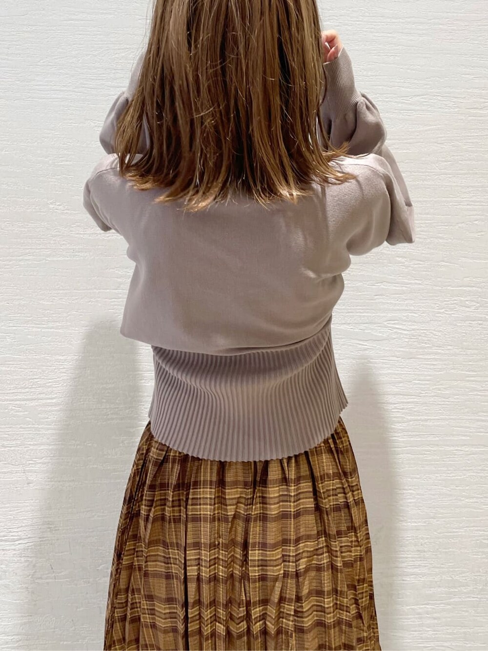 ブラウン系のスカート、ベージュ系のTシャツ/カットソー、ブラック系のブーツを着用したレディースの秋コーディネートの6枚目の写真