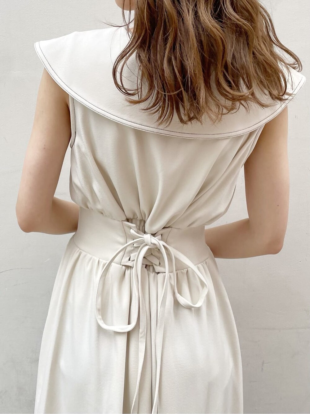 ブラック系のサンダル、ブラック系のハンドバッグ、ホワイト系のワンピースを着用したレディースの春コーディネートの6枚目の写真