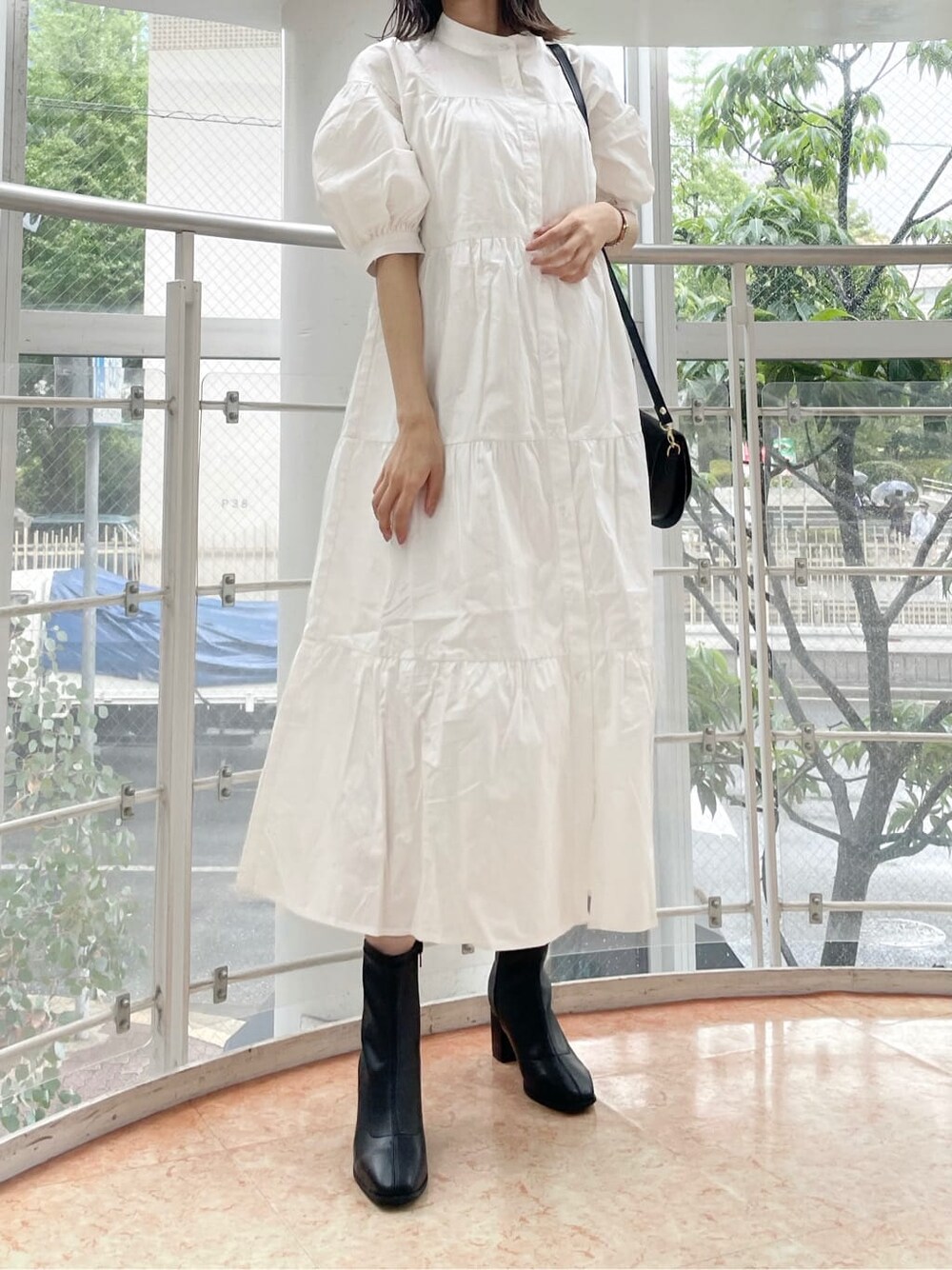 ホワイト系のワンピース、ブラック系のショルダーバッグ、ベージュ系のニット/セーターを着用したレディースの秋コーディネートの2枚目の写真