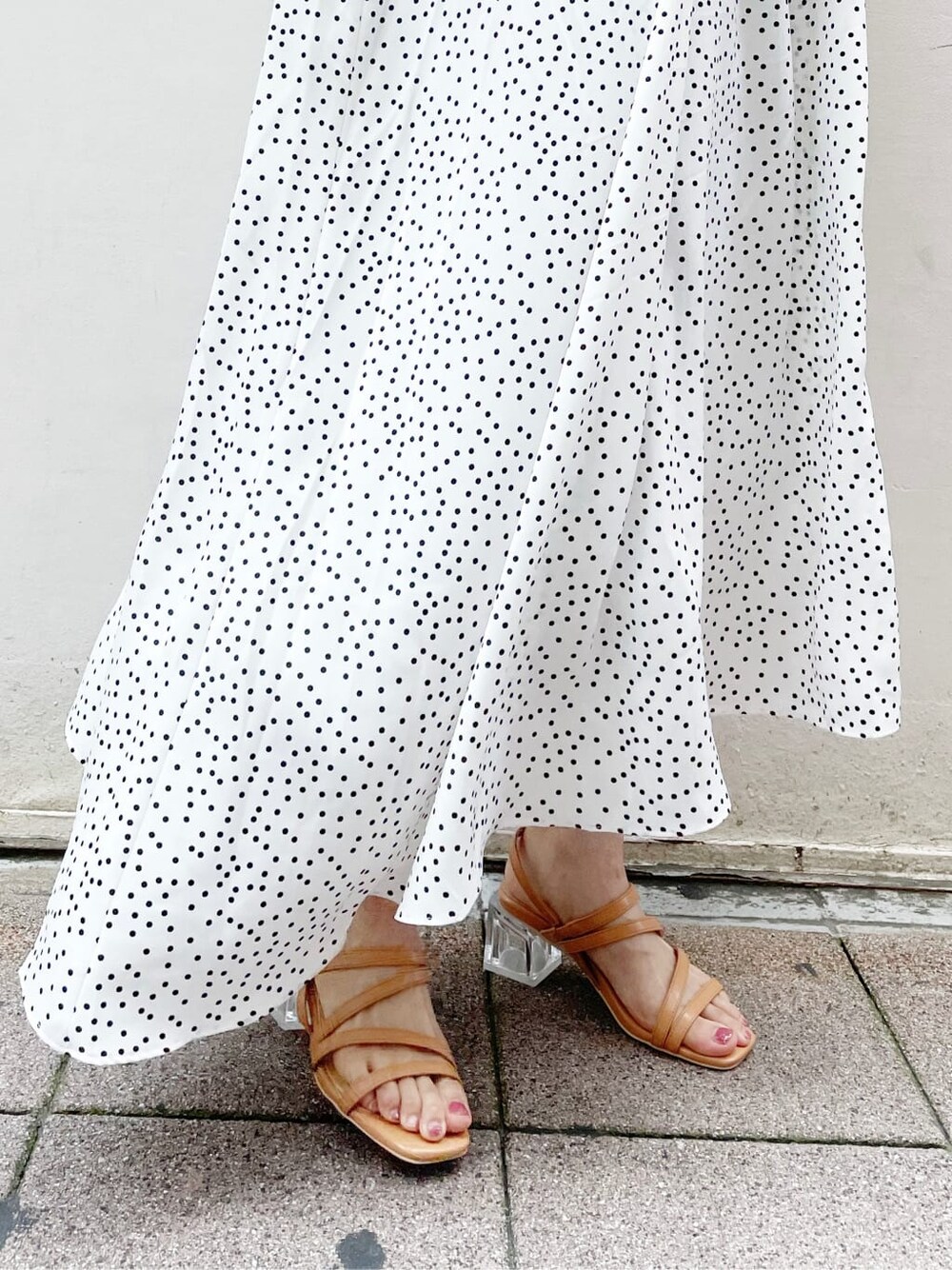 オレンジ系のサンダル、ホワイト系のワンピース、ゴールド系のブレスレットを着用したレディースの夏コーディネートの10枚目の写真