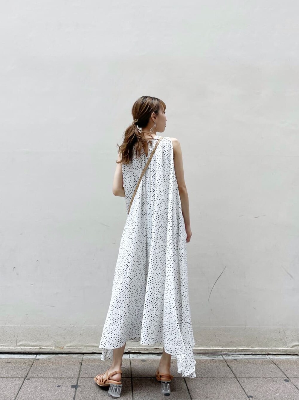 オレンジ系のサンダル、ホワイト系のワンピース、ゴールド系のブレスレットを着用したレディースの夏コーディネートの2枚目の写真