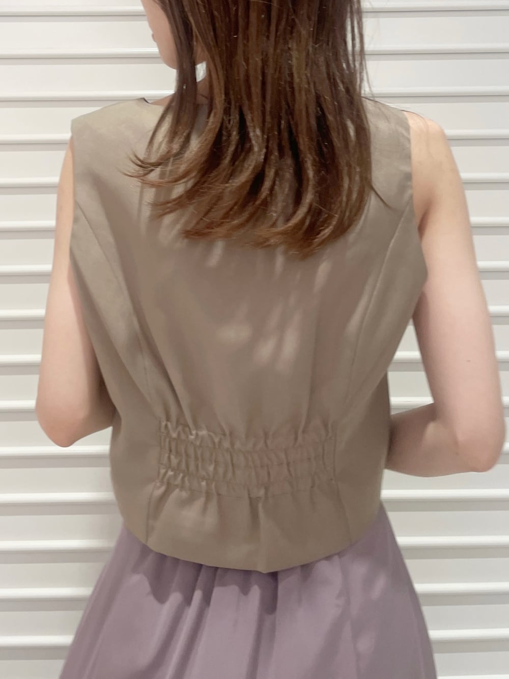 ブラウン系のベスト、ピンク系のスカート、ブラック系のローファーを着用したレディースの夏コーディネートの7枚目の写真