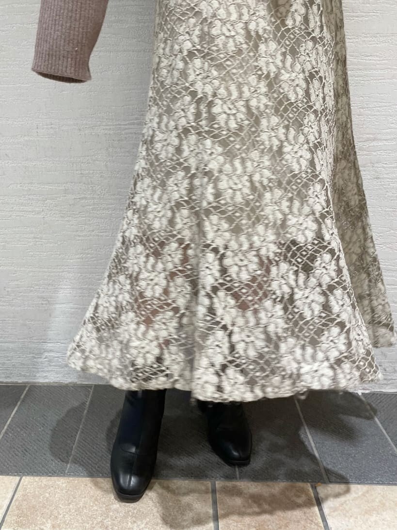 ベージュ系のスカート、ブラック系のブーツ、ベージュ系のニット/セーターを着用したレディースの秋コーディネートの10枚目の写真