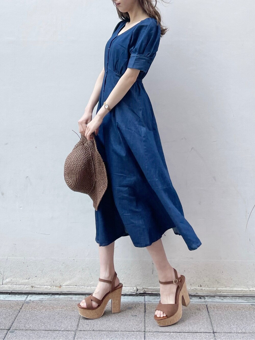 ブルー系のワンピース、ブラウン系のサンダル、ブラウン系のハットを着用したレディースの春コーディネートの4枚目の写真