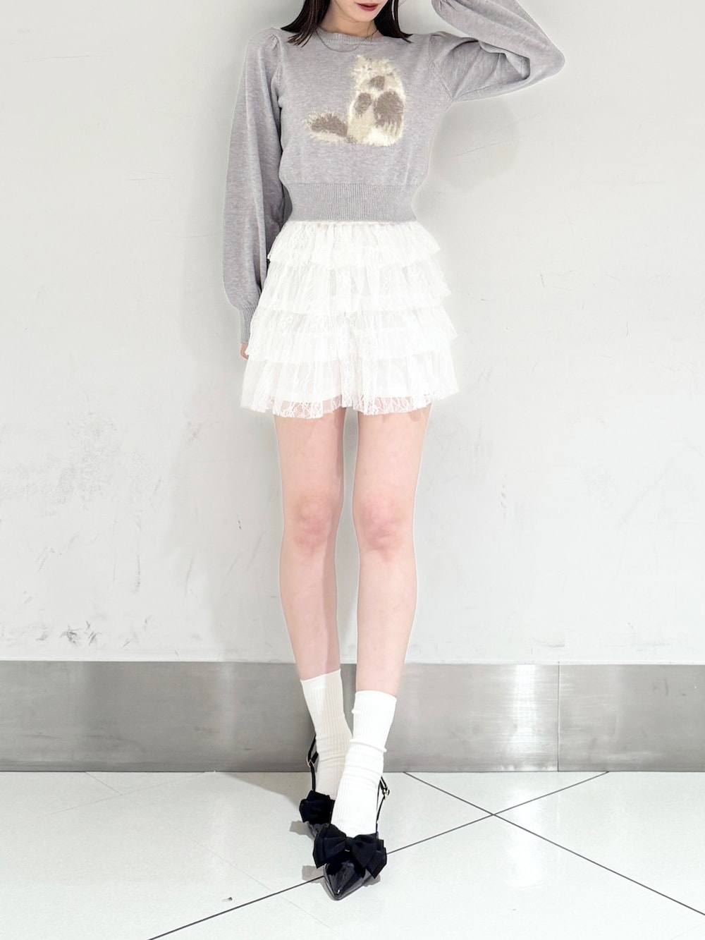 ブラック系のパンプス、ホワイト系のその他パンツ、グレー系のニット/セーターを着用したレディースの春コーディネートの2枚目の写真