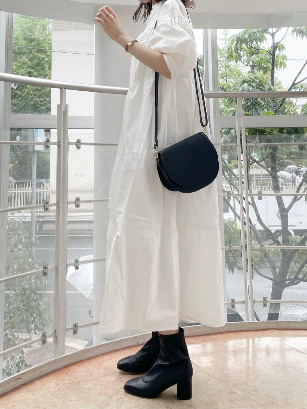 ホワイト系のワンピース、ブラック系のショルダーバッグ、ベージュ系のニット/セーターを着用したレディースの秋コーディネートの3枚目の写真